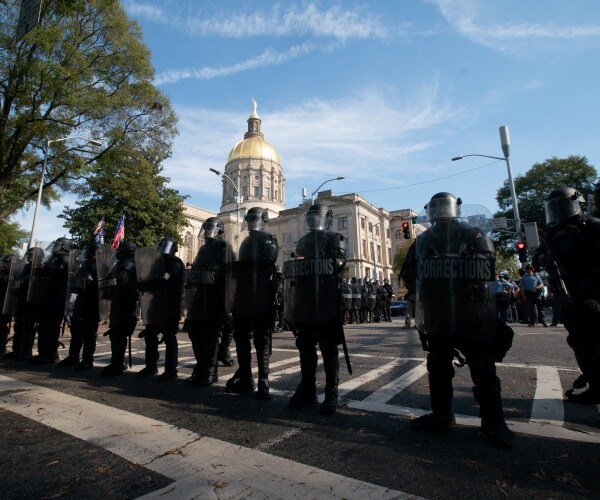 police in riot gear form a line in atlanta