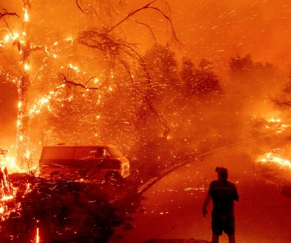 Bruce McDougal watches embers fly over his property from a fire