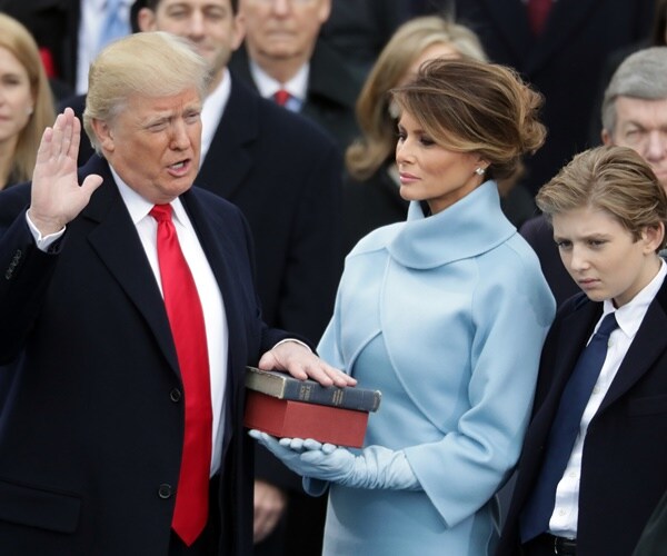 president trump stands next to his wife and son and is sworn in