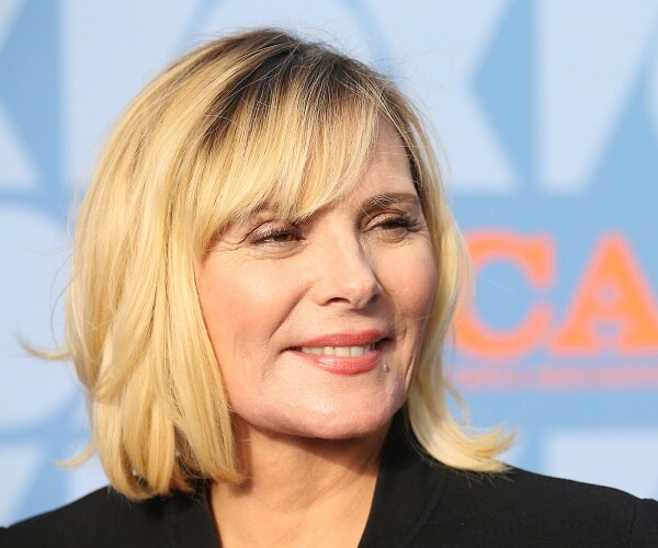 kim cattrall stands on red carpet