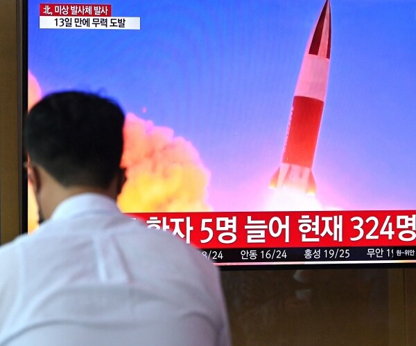 People watch a television news broadcast showing footage of a North Korean missile test