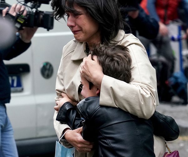 An adult and child embrace near the elementary school