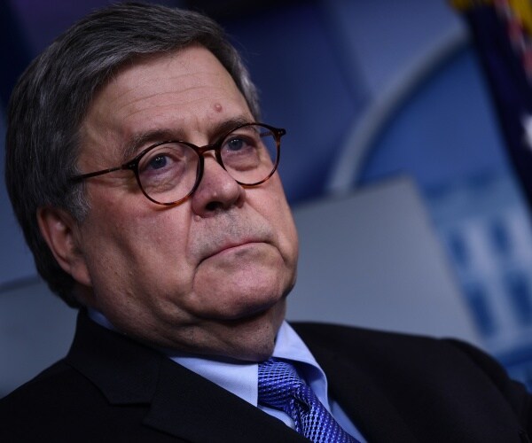 barr in a suit and blue tie in the press briefing room