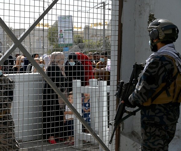taliban fighter stands guard at airport gate