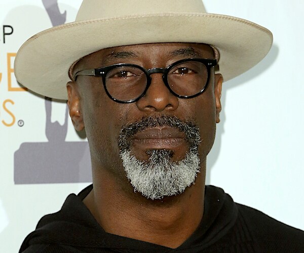 actor Isaiah Washington wearing a cowboy hat and glasses on the red carpet