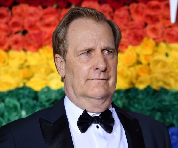 daniels in front of a rainbow background in a suit and bow tie