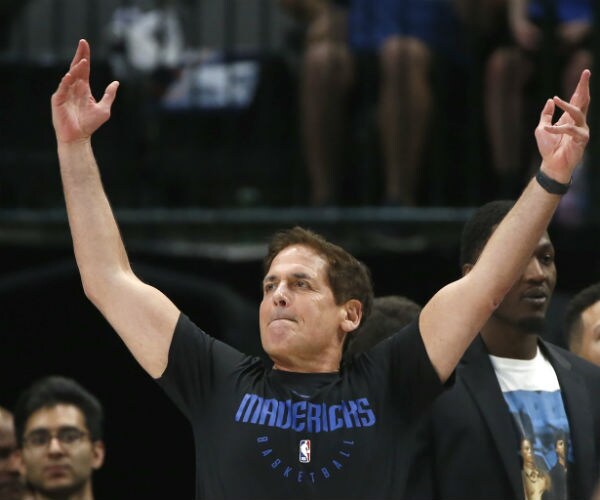  Dallas Mavericks owner Mark Cuban is seen with both arms raised wearing his team shirt