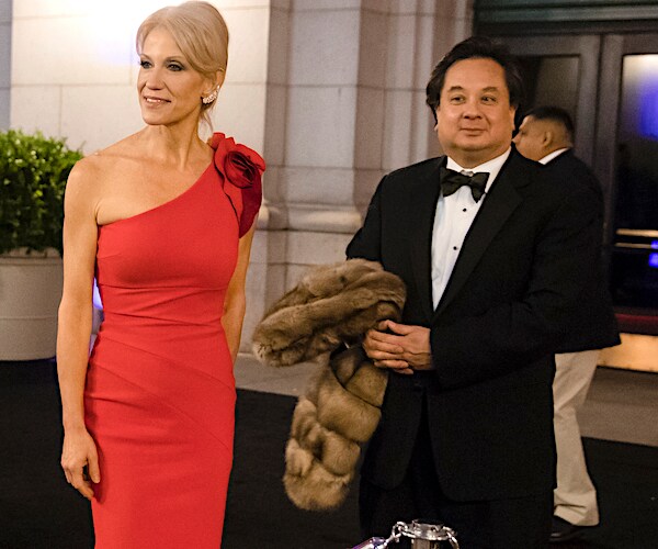 kellyanne conway wears a bright red dress as her husband george conway holds her coat
