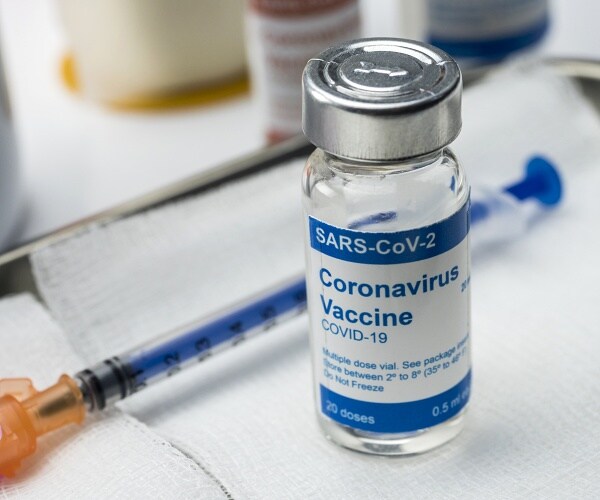 coronavirus vaccine and needle on medical tray
