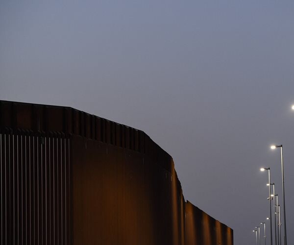 The border wall illuminated at night