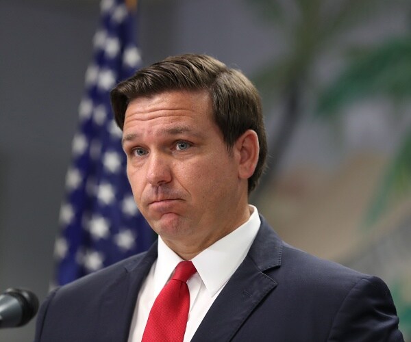 desantis in a suit and red tie