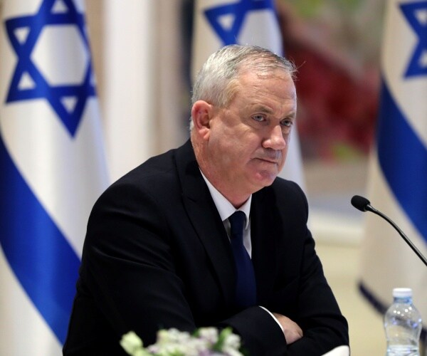 Benny Gantz sits with his arms folded.