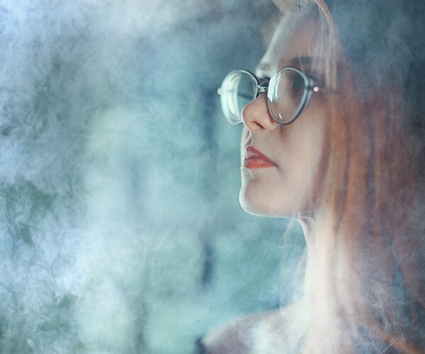 a young woman surrounded by vaping smoke