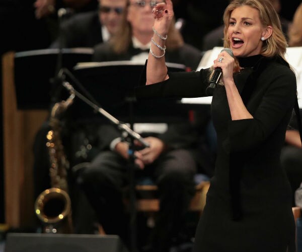 faith hill is shown singing in a black dress