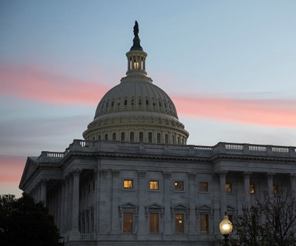 the capitol building sits before a colorful, red sky at dusk