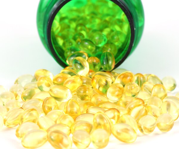 vitamin d capsules spilling out of a pill bottle