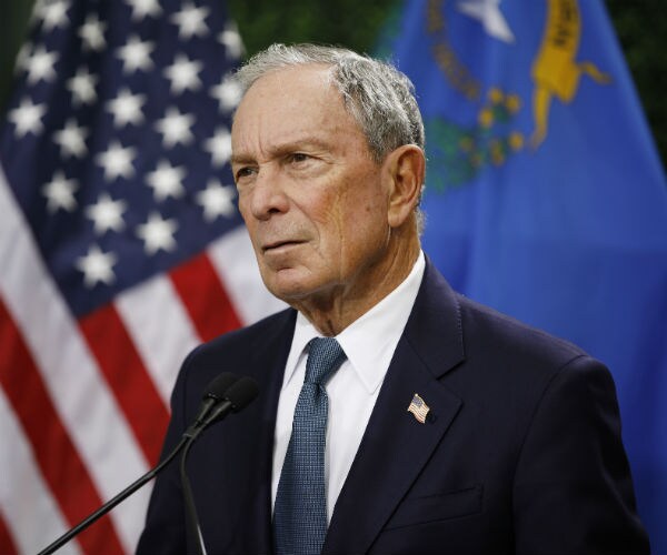 former new york city mayor michael bloomberg is shown with the American flag draped in the background