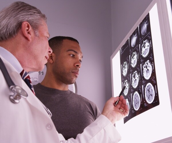 doctor reviewing brain x-rays with young man