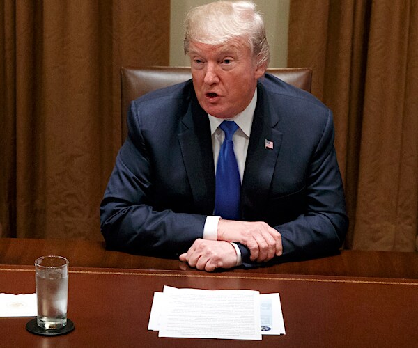 president donald trump sits and speaks from the cabinet desk in the west wing