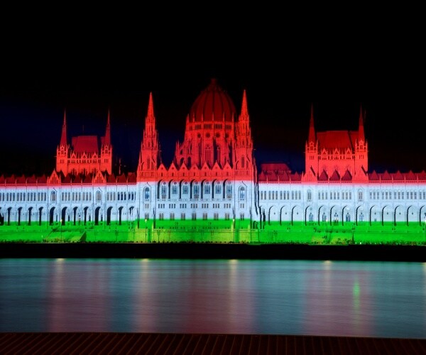 colors of the hungarian flag light up the parliament building