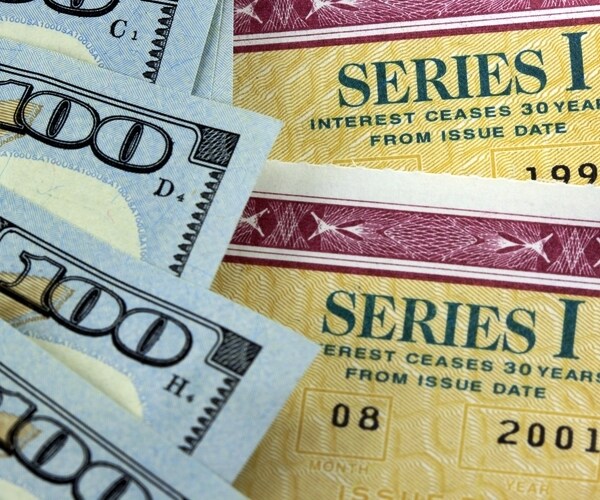 united states treasury savings bonds with one hundred dollar bills 

