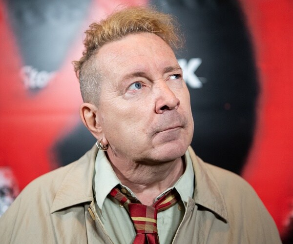john lydon stands on red carpet