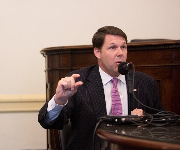 arrington in a suit and purple tie