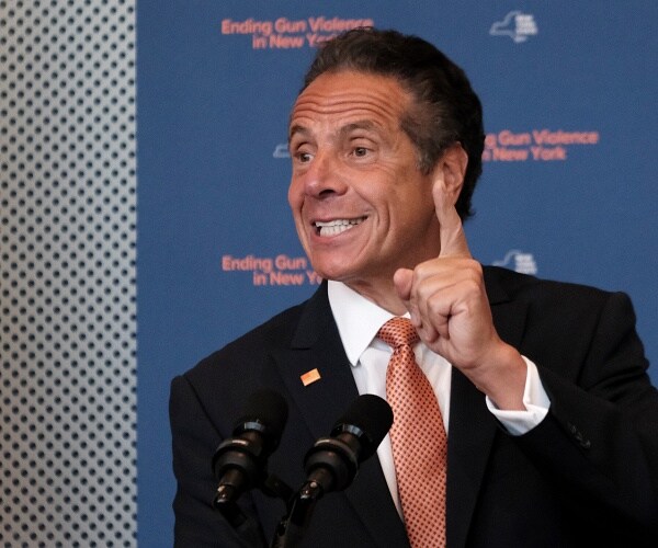 andrew cuomo holds up one finger as he speaks to press
