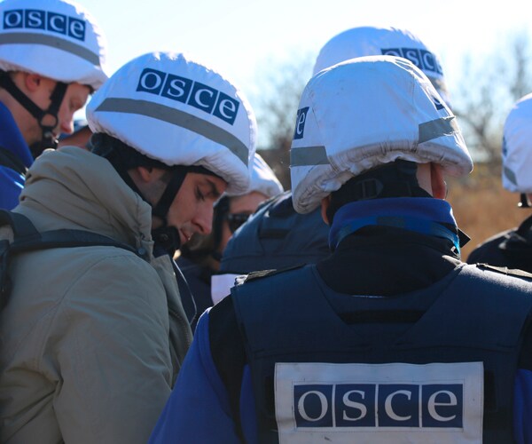 members of the organization for security and cooperation in europe (OSCE) near a battlefield in Ukraine