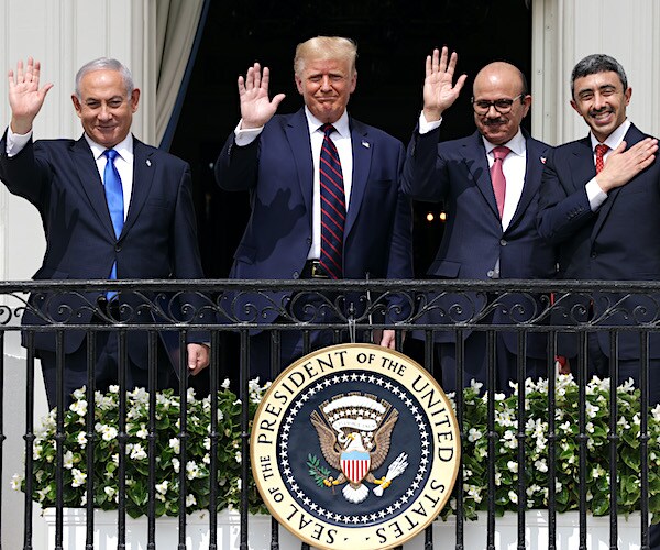 a group of leaders wave from the white house balcony after signing the abraham accords