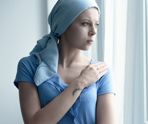 female cancer patient looks out window