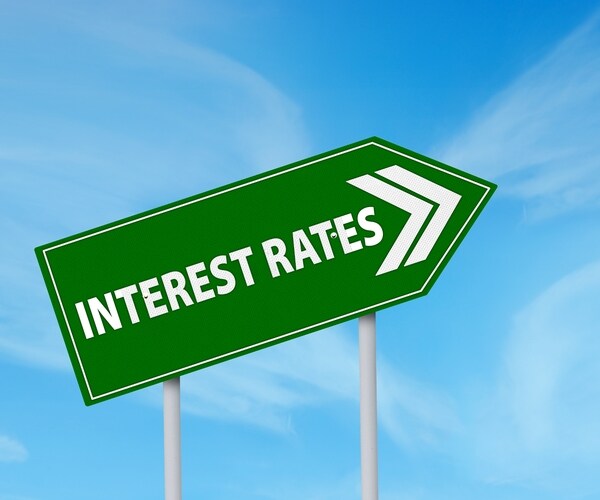 green roadsign of higher interest rates ahead against blue sky 