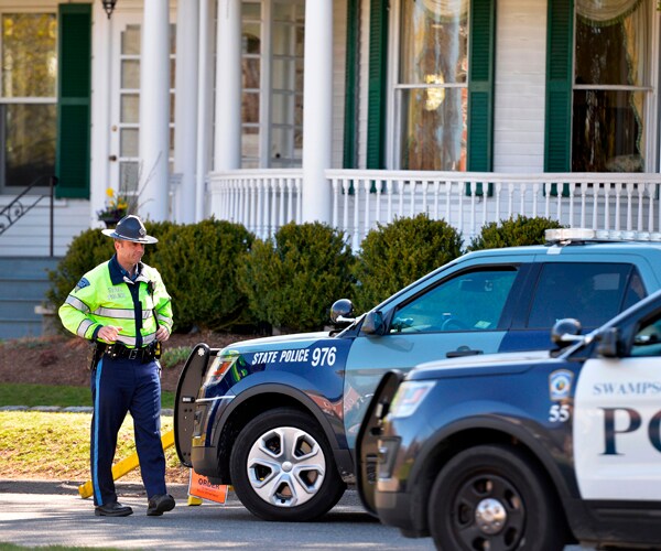 a massachusetts state trooper stands outside gov charlie bakers home