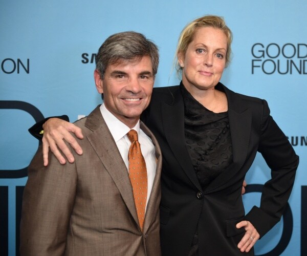 george stephanopoulos in a gray suit and ali wentworth in a black dress with blue background