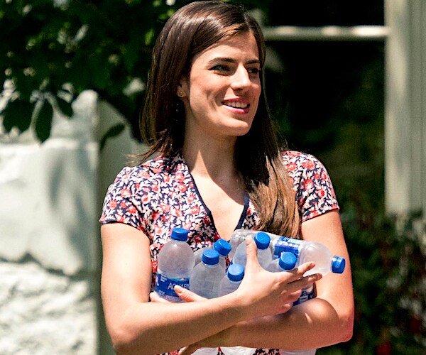 Madeleine Westerhout carries bottles of water into the white house rose garden