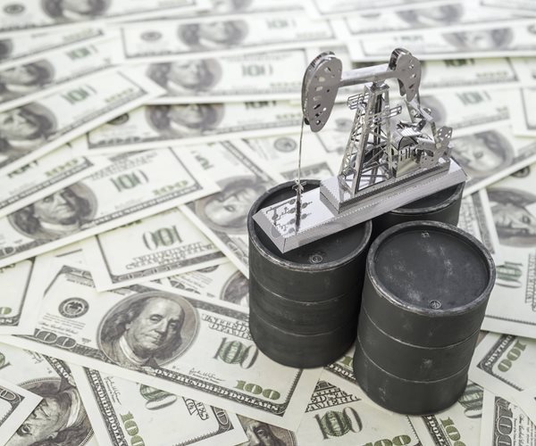 oil barrels and oil well on hundred dollar bills