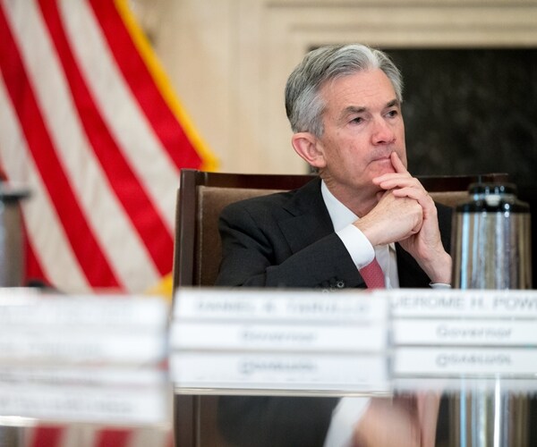 jay powell sitting behind desk