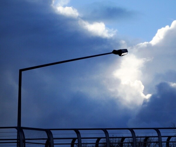 streetlight against a blue cloudy sky