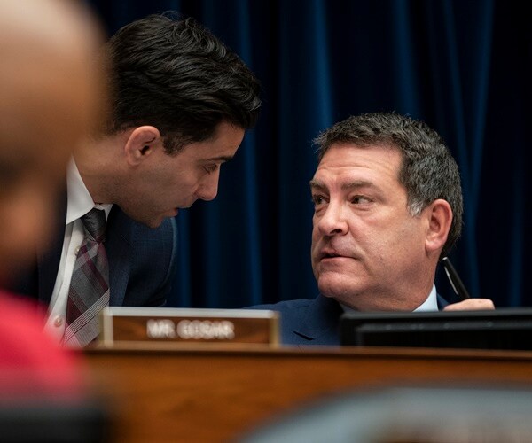 mark green speaks with an aide during a committee hearing