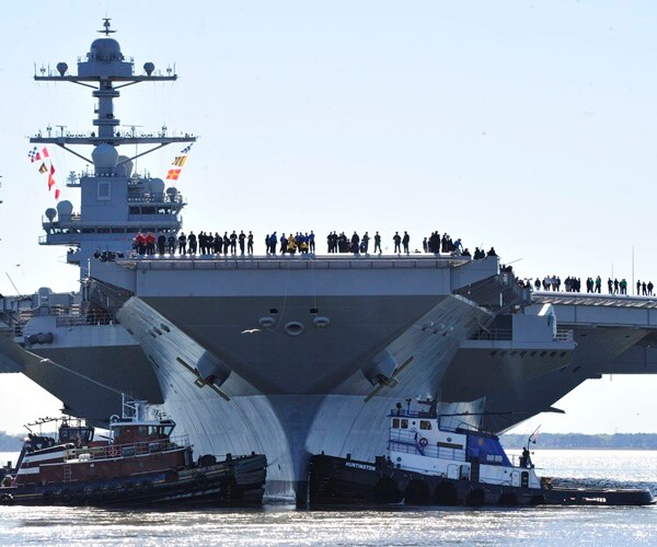 navy personnel are on the edge of the deck of the u.s.s. gerald ford