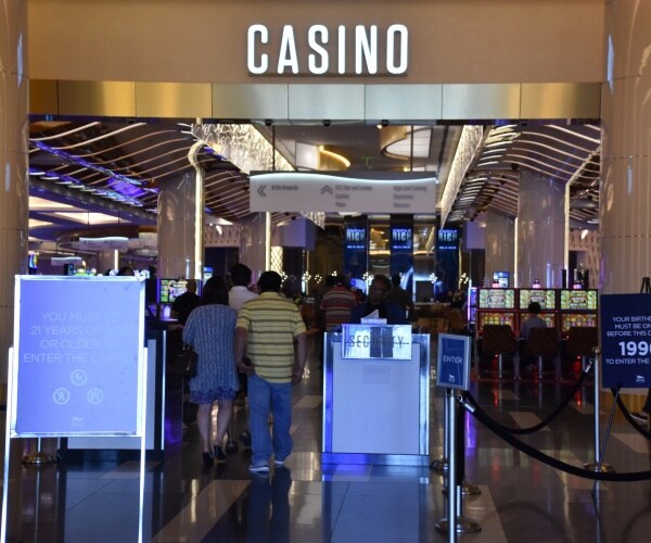 casino is shown with people walking in near a sign displaying a "21 and over" age limit