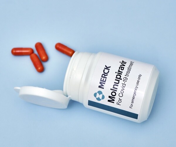 a bottle spilling out pills of Merck COVID treatment pill molnupiravir
