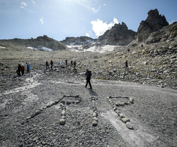 r i p spelled out in stones at the site of the glacier