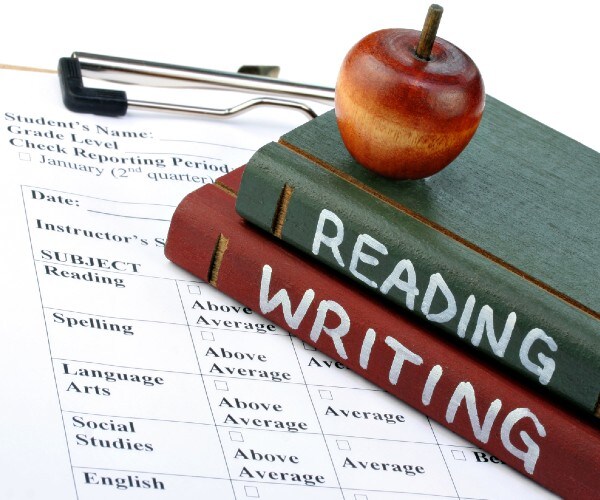a report card with books labled reading and writing and an apple