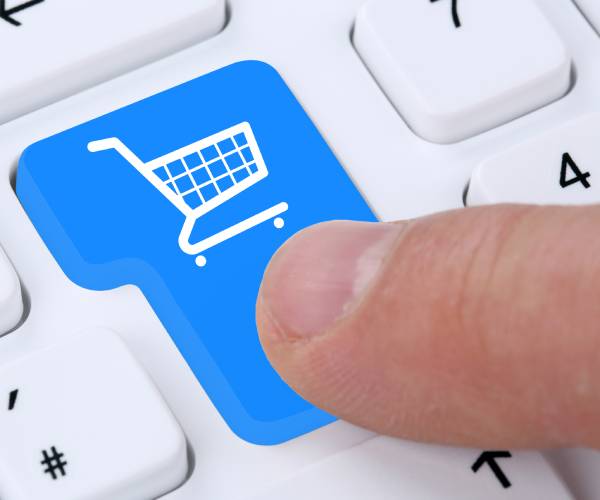 a finger pushing a computer button with a shopping cart on it