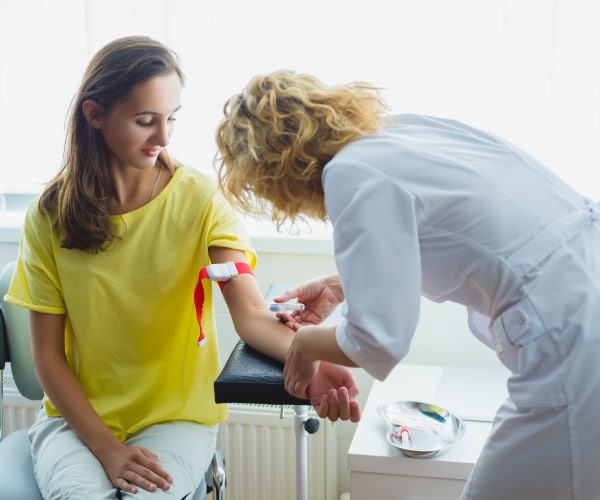 young woman having blood drawn