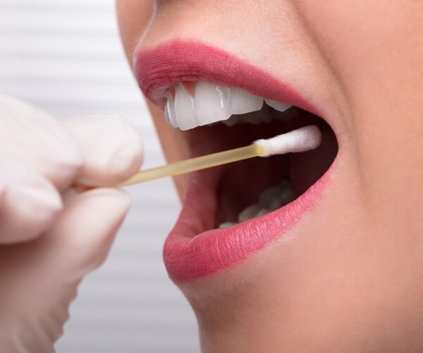 a woman's saliva is swabbed.