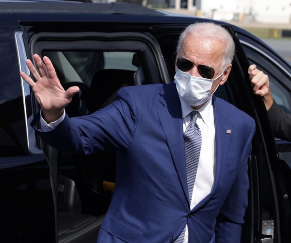 joe biden wearing a mask gets out of a car
