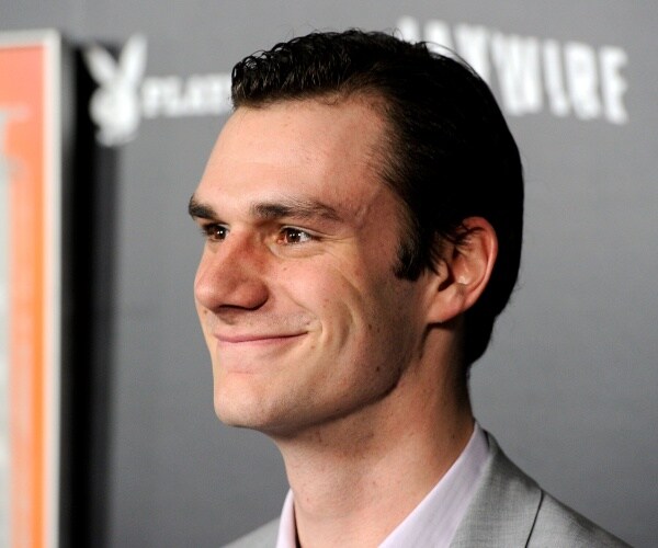 hefner in a light gray suit smiling