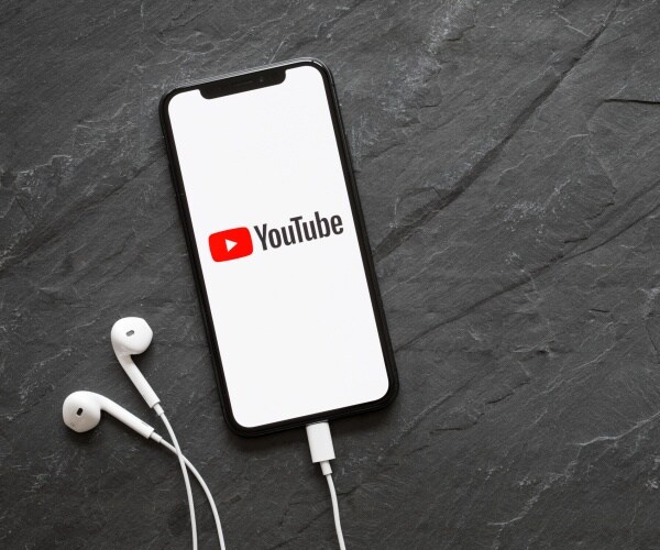 youtube app opened on an iphone with headphones